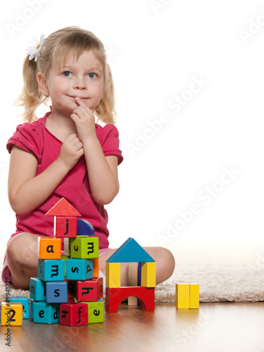 Photo: Pensive little girl near toys Pensive little girl near toys