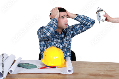 Photo: stressed worker looking at a clock stressed worker looking at a clock