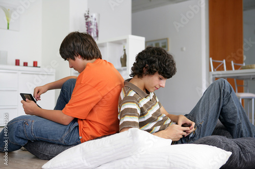 Photo: Teenage boys with handheld devices Teenage boys with handheld devices