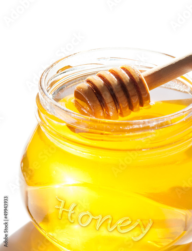 Photo: Honey dipper in jar isolated on white background Honey dipper in jar isolated on white background