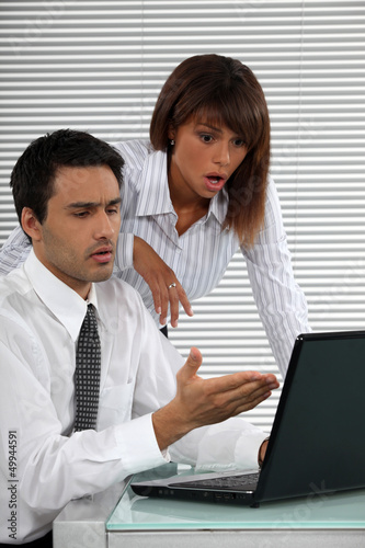 Photo: Two businessworkers shocked by laptop screen Two businessworkers shocked by laptop screen