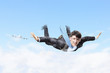 Young businessman flying with parachute on back