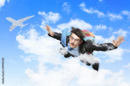 Photo: Young businessman flying with parachute on back Young businessman flying with parachute on back