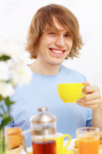 Photo: Young happy man drinking tea Young happy man drinking tea