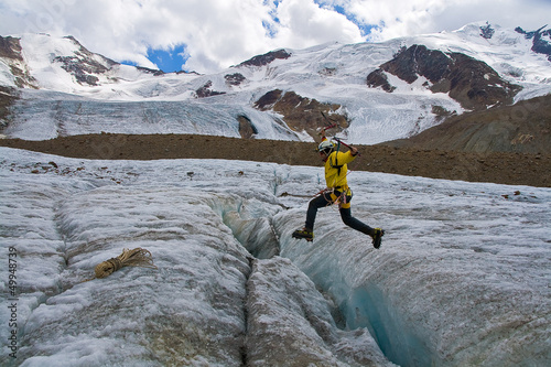 Photo: Alpinista che salta Crepaccio Alpinista che salta Crepaccio