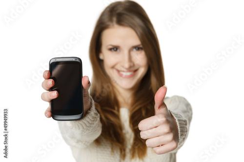 Photo: Closeup of happy woman showing mobile phone gesturing thumb up Closeup of happy woman showing mobile phone gesturing thumb up