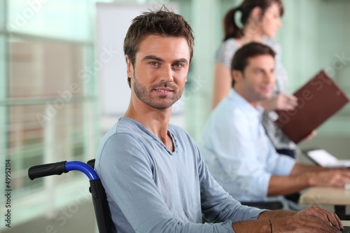Photo: Man in a wheelchair working in an office Man in a wheelchair working in an office