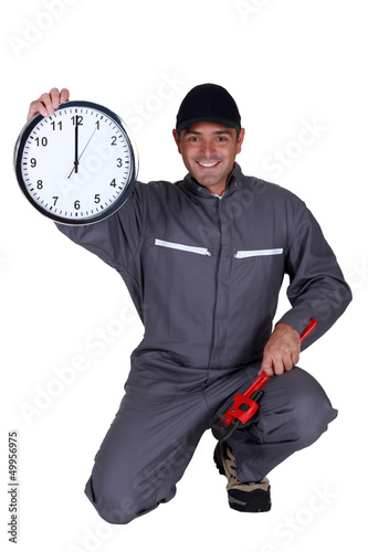Photo: Plumber holding up a clock Plumber holding up a clock