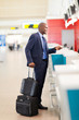 Photo: african businessman standing by airport check in counter african businessman standing by airport check in counter