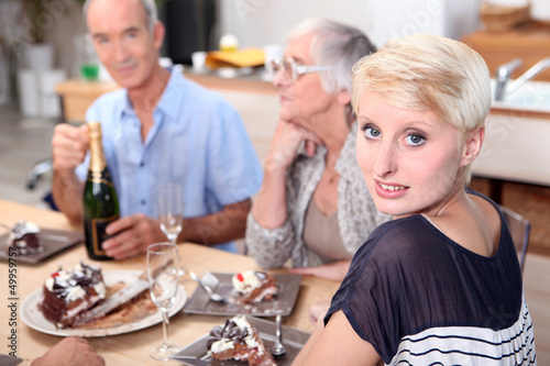 Photo: Family gathered around table eating cake Family gathered around table eating cake