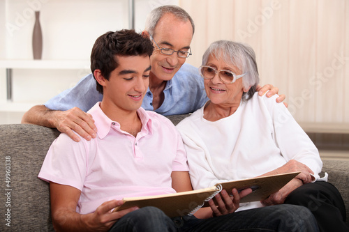 Photo: Family looking through photo album Family looking through photo album