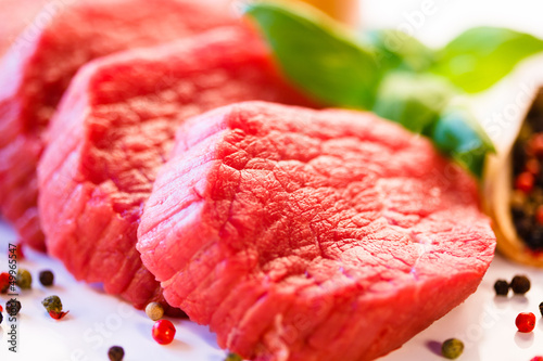 Photo: Raw beef and vegetables on white background Raw beef and vegetables on white background