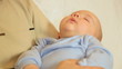 Baby boy sleeping on hands of her father