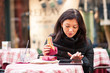 Woman using tablet outdoors sit in a bar. Shallow depth of field