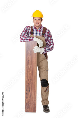 Photo: Worker with laminate piece Worker with laminate piece