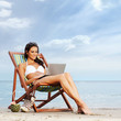 A young and lovely brunette woman relaxing on the beach