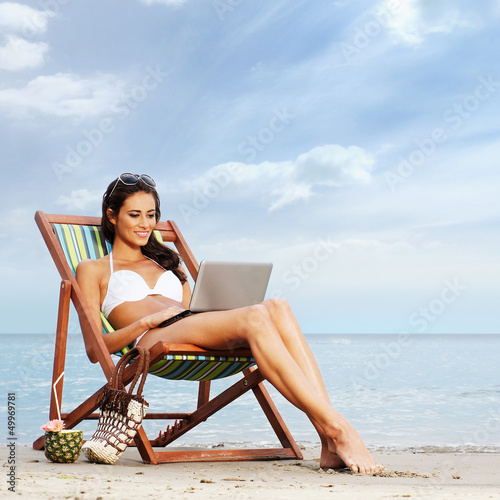 Photo: A young and lovely brunette woman relaxing on the beach A young and lovely brunette woman relaxing on the beach