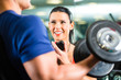 Personal Trainer in gym and dumbbell training