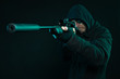 Sniper with beard in black holding gun. Studio shot.