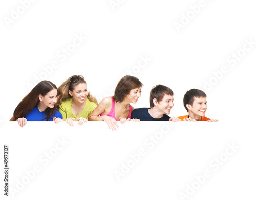 Photo: A group of happy teenagers holding a white blank banner A group of happy teenagers holding a white blank banner
