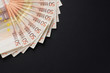 Close-up image of 50 euro banknotes on a dark table