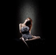 A young and sexy redhead woman sitting in erotic fur