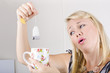 Worker with look of relief holding tea bag and cup