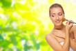 Young healthy girl with makeup brush on spring background