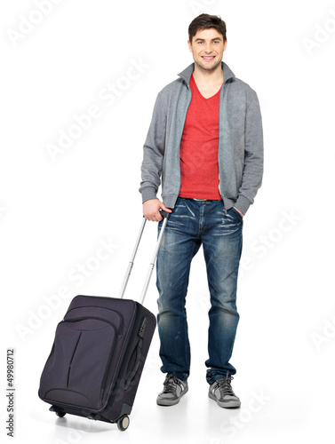 Photo: Full portrait of smiling happy man with suitcase Full portrait of smiling happy man with suitcase
