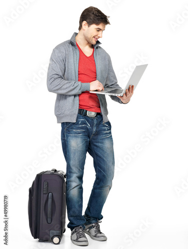 Photo: Full portrait of man with suitcase and laptop Full portrait of man with suitcase and laptop