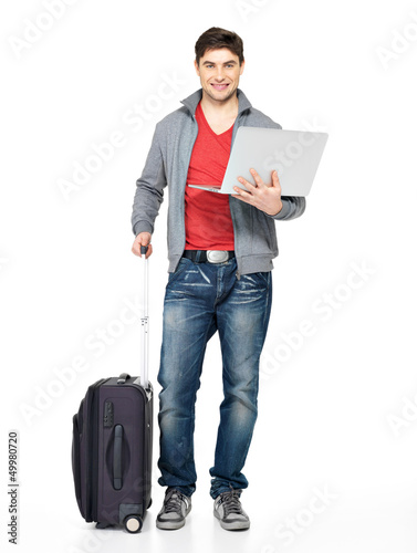 Photo: Full portrait of man with suitcase and laptop Full portrait of man with suitcase and laptop