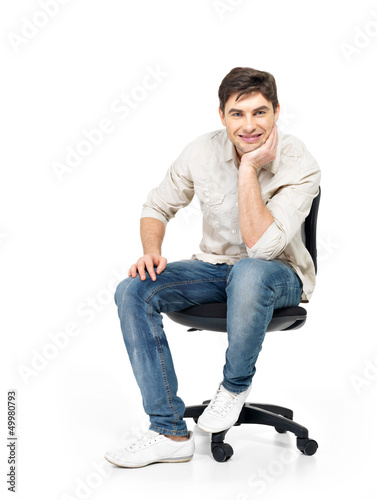 Photo: Portrait of smiling happy man sits on office chair Portrait of smiling happy man sits on office chair