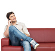 man sits on the divan and  speaks on mobile phone