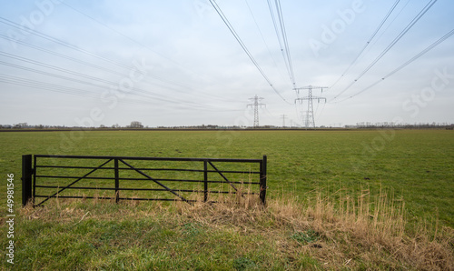 Photo: Dutch farmland with a steel fence and high voltage lines. Dutch farmland with a steel fence and high voltage lines.