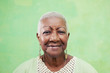Foto: Portrait of senior black woman smiling at camera on green backgr Portrait of senior black woman smiling at camera on green backgr