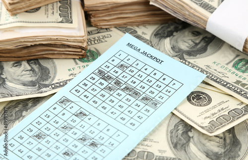 Photo: Lottery ticket and money, close up Lottery ticket and money, close up