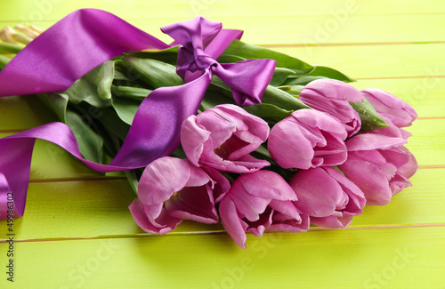 Photo: Beautiful bouquet of purple tulips on green wooden background Beautiful bouquet of purple tulips on green wooden background