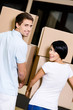 Back view of happy couple carrying cardboard packages