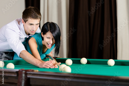 Photo: Man teaching girl to play billiard Man teaching girl to play billiard