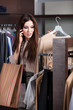 Speaking on the mobile phone and choosing clothes in the store