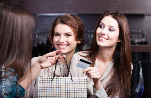 Photo: Pretty women pay with credit card Pretty women pay with credit card