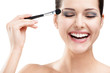 Photo: Woman applying make-up with brush, isolated on white Woman applying make-up with brush, isolated on white