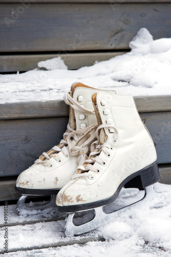 Photo: Pair of old white skates on snowy stairs Pair of old white skates on snowy stairs
