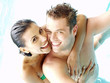 Pareja latina disfrutando en una piscina.