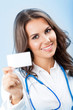 Young female doctor showing blank business card