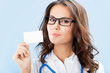 Young female doctor showing blank business card