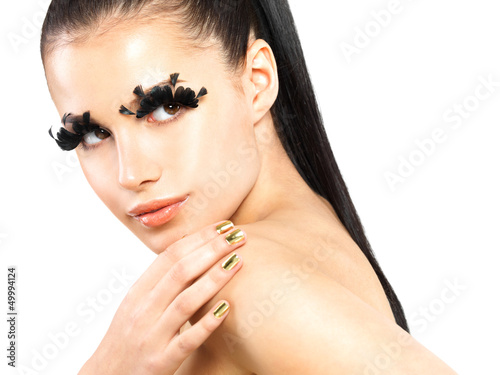 Photo: Woman with golden nails and style makeup Woman with golden nails and style makeup