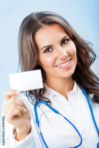 Photo: Young female doctor showing blank business card Young female doctor showing blank business card