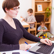 business woman working laptop her child playing at the back