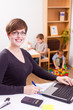 business woman working laptop her child playing at the back